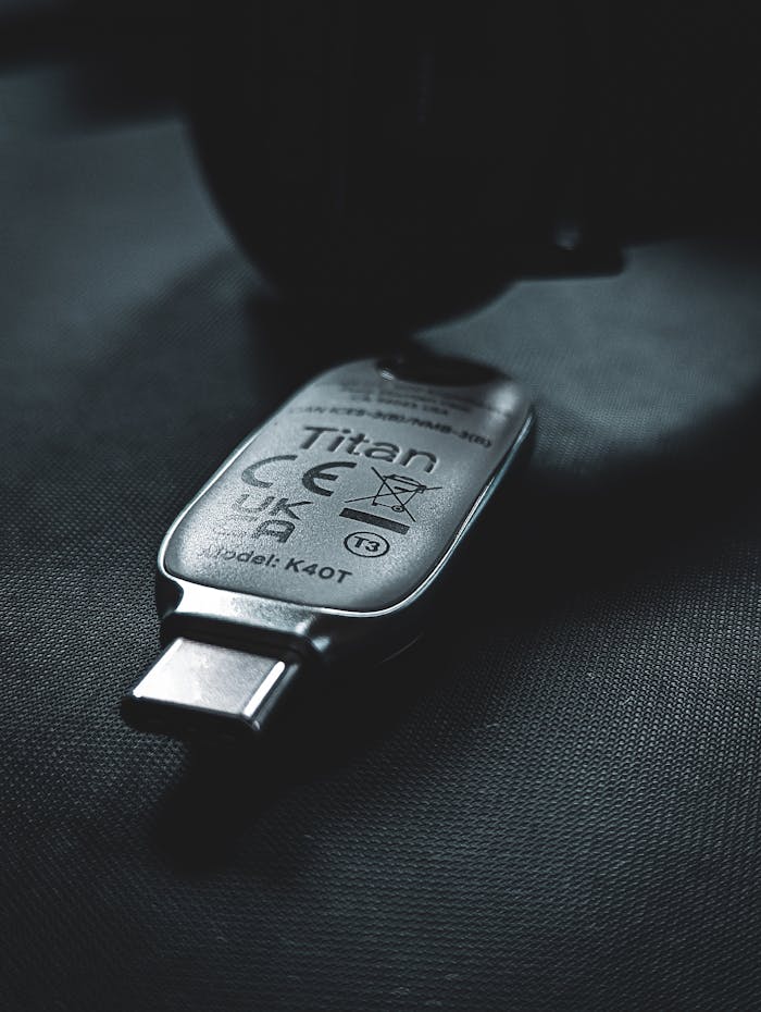 A sleek USB-C security key lies on a textured dark surface, emphasizing modern technology.